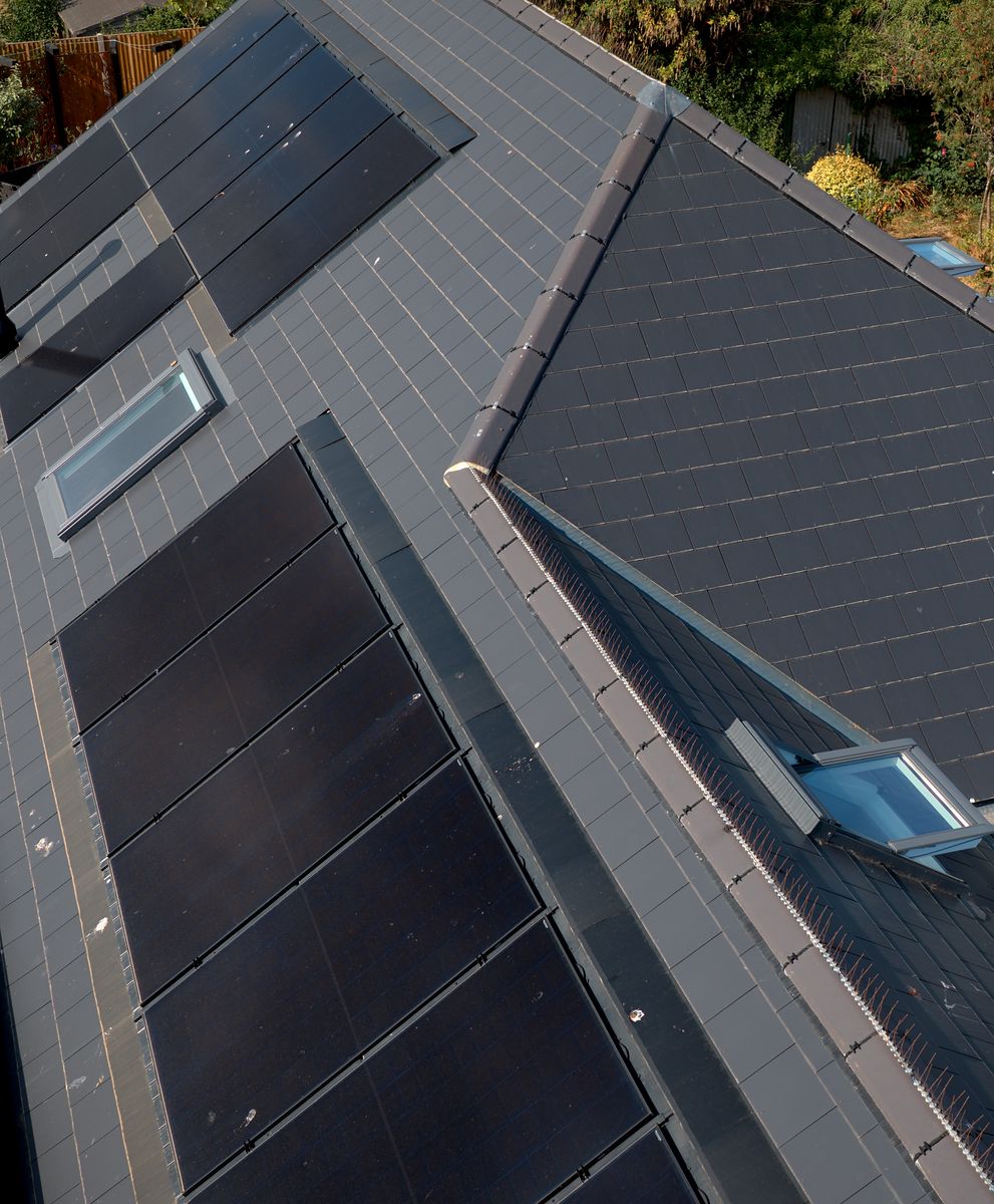 Roof with in-roof solar panels and rooflights