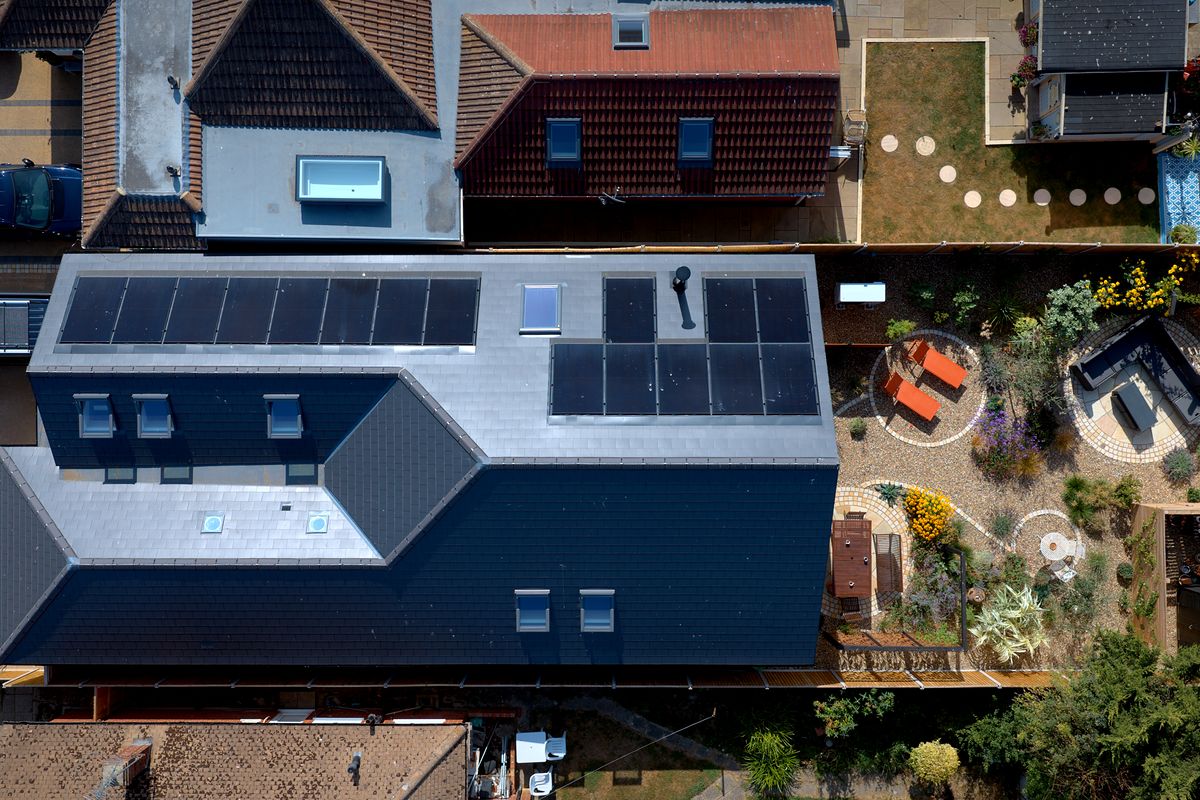 Aerial view of a renovated home with in-roof solar panels and rooflights