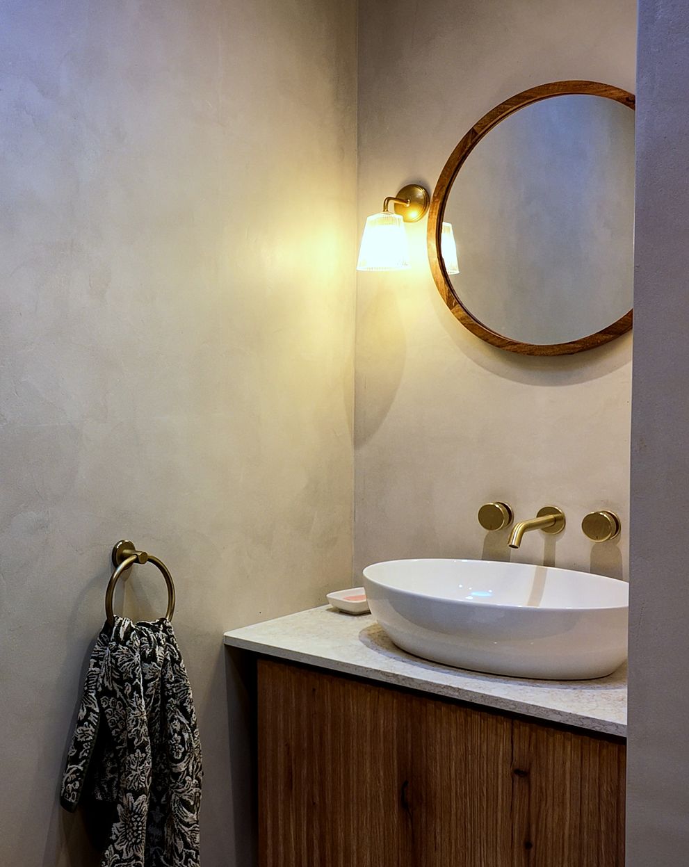 Bathroom with plaster-finish walls, brass taps and a countertop basin