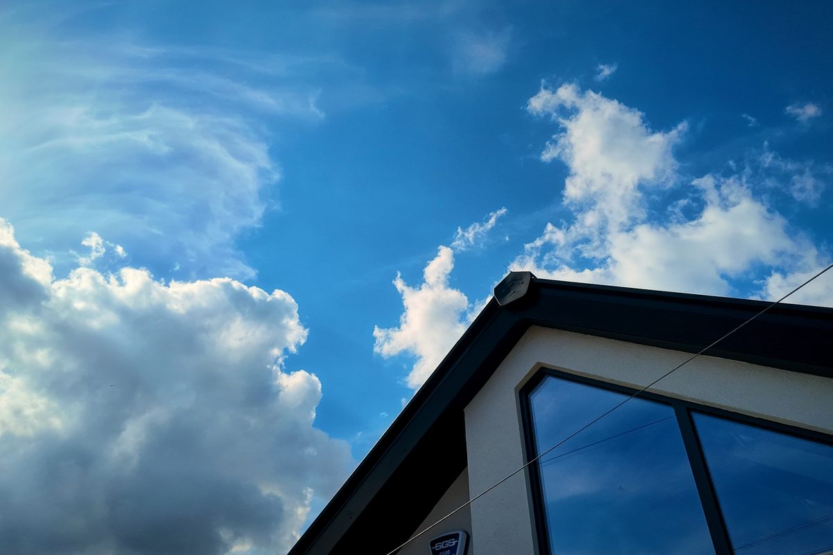 Glazed gable and dark roofline against a blue sky