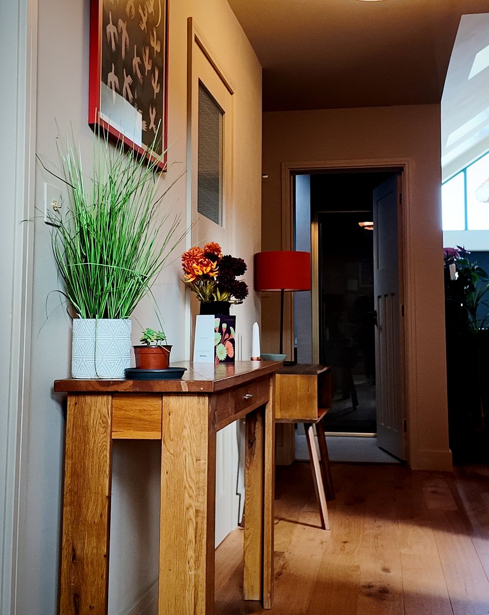 Hallway with a console table and wood flooring