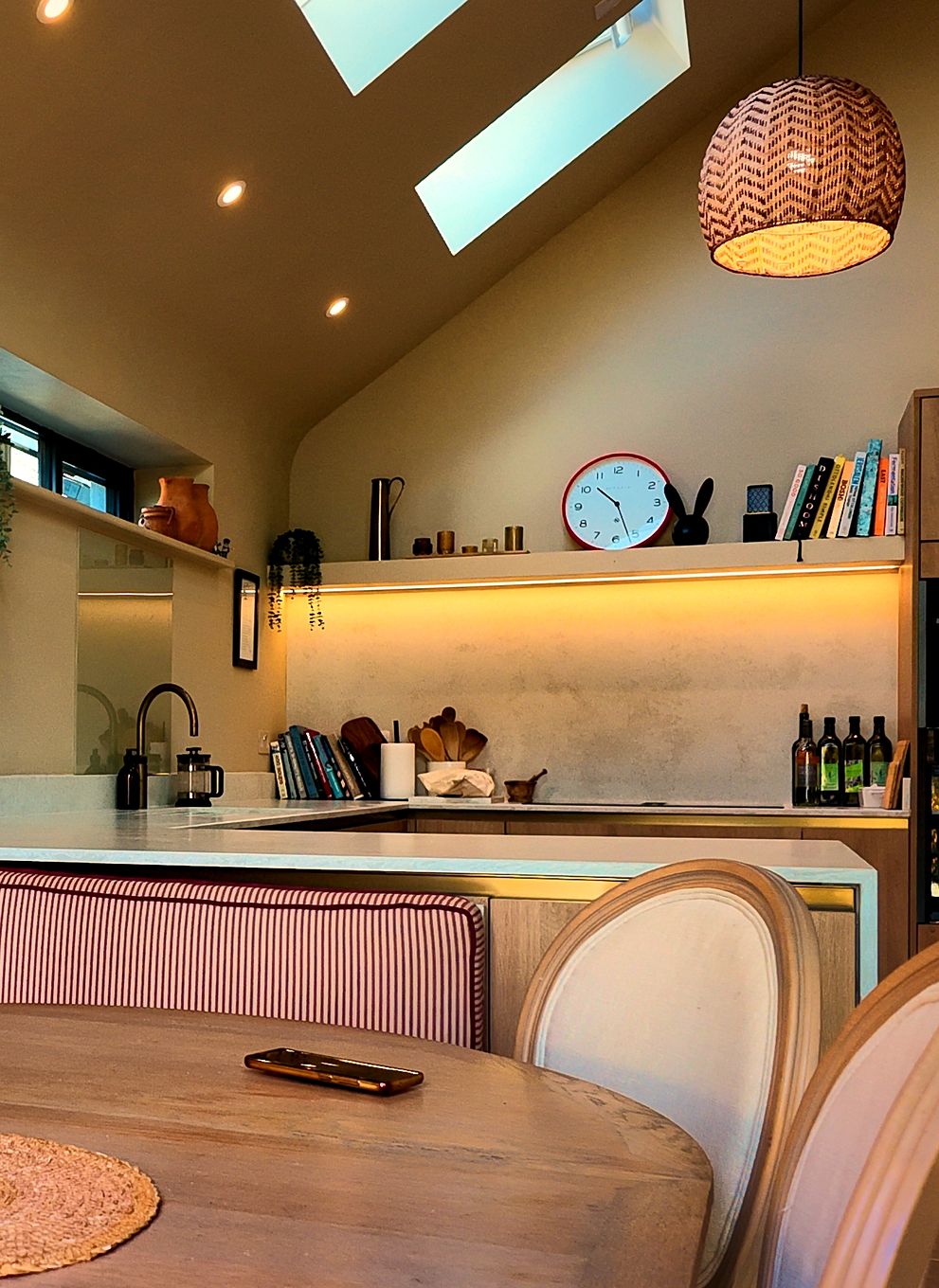 Open-plan kitchen and dining area under a vaulted ceiling with rooflights