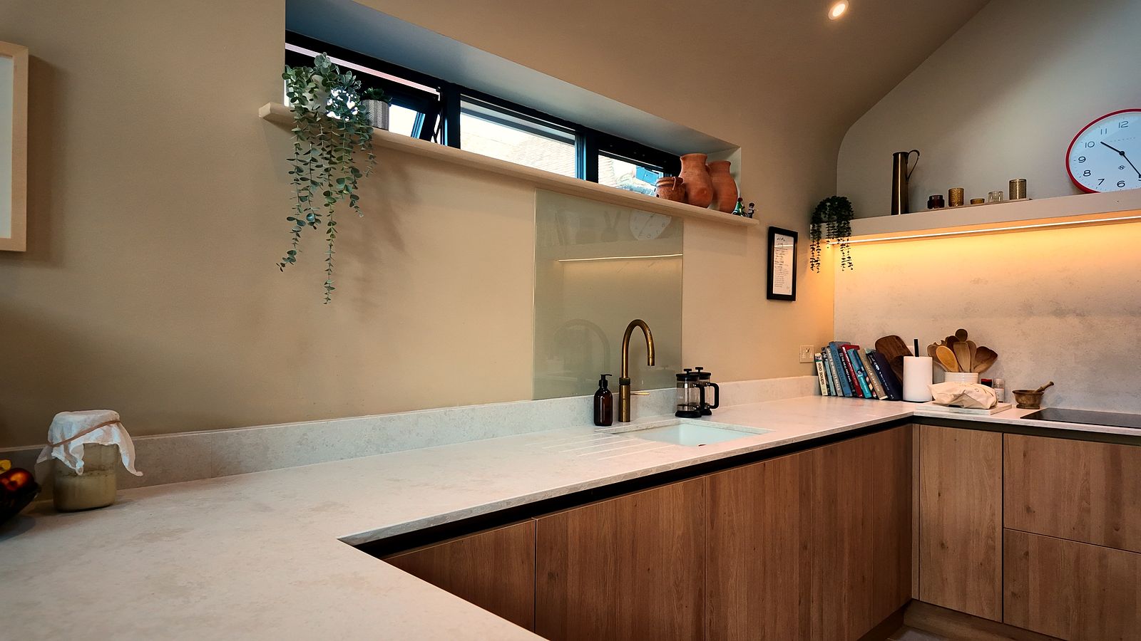 L-shaped kitchen worktop beneath high-level windows
