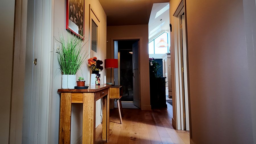 Hallway with a console table and wood flooring
