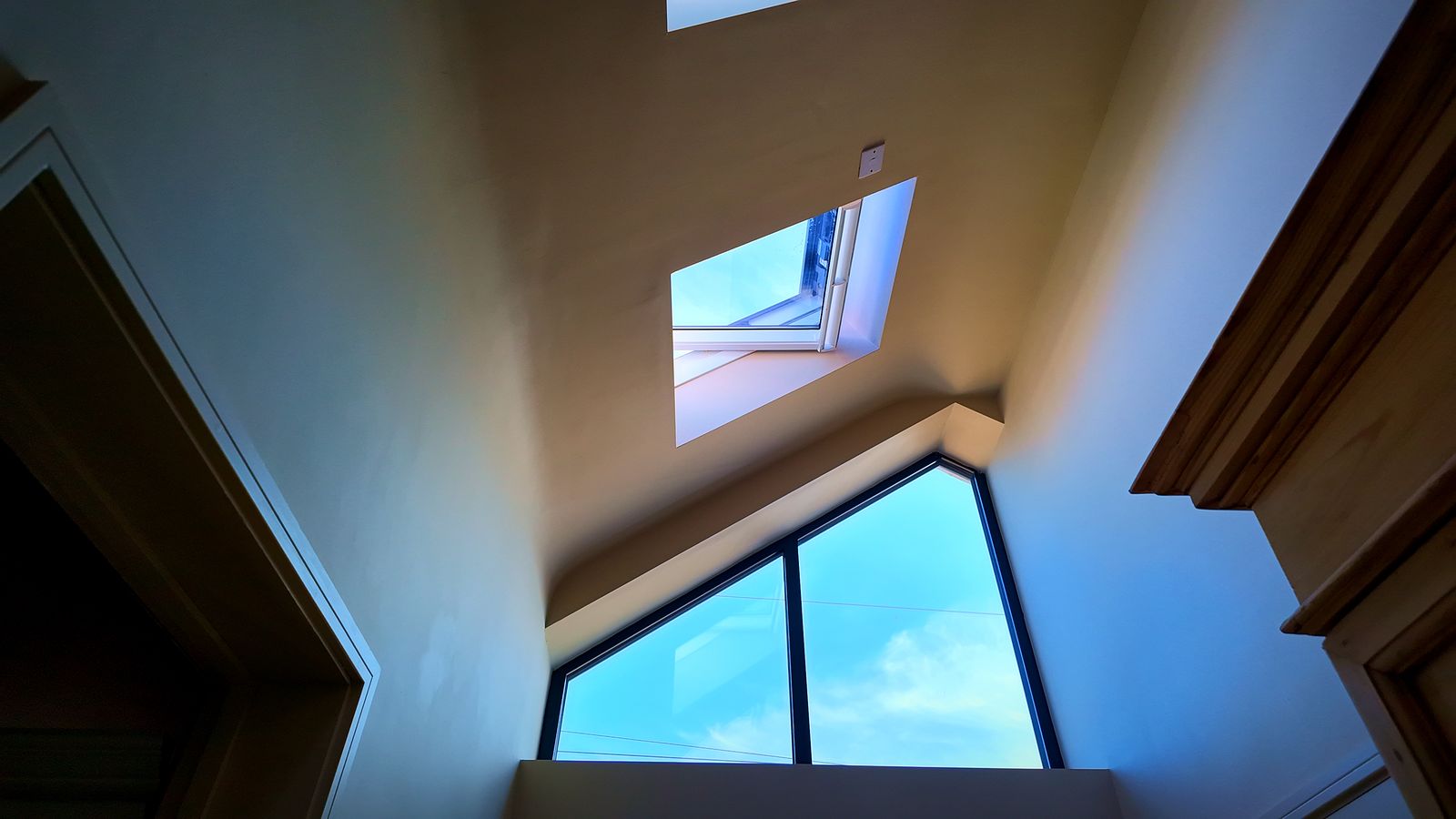 Vaulted ceiling with a glazed gable window and rooflight